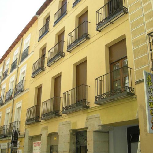 Fachada amarilla con pequeñas terrazas